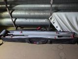 a bag of luggage sitting on the floor next to a pile of pipes