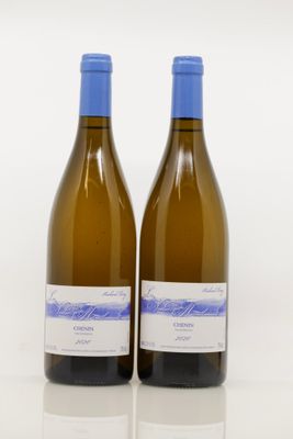 deux bouteilles de vin blanc posées l'une à côté de l'autre sur une table
