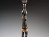 une statue en bronze représentant une femme tenant un bol sur la tête