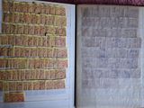 deux livres ouverts, sur lesquels sont apposés des timbres, posés sur une table