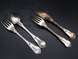 three silver spoons and a fork on a black background