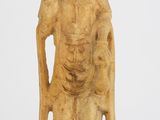 une vieille statue représentant une femme tenant un bâton, sur fond blanc