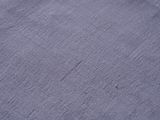 closeup of a blue cloth textured surface with a small hole in the middle of it