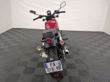 a red motorcycle parked in a room with a checkered floor