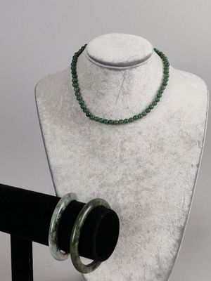 necklace and bracelet on a mannequin stand with a white background