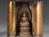 une image d'une statue en bronze d'un bouddha dans un coffret en bois