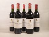 quatre bouteilles de vin rouge sont alignées sur une surface blanche