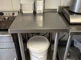 a kitchen with a stove, sink, and a pot on the counter