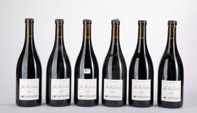six bouteilles de vin sont alignées sur une table
