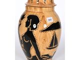 a black and gold vase with a painting on it