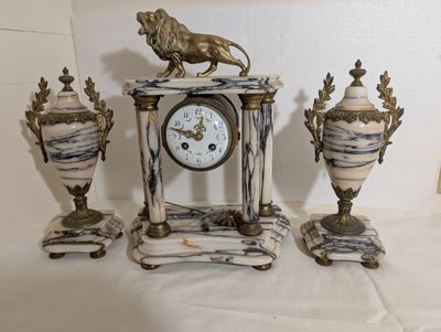 Garniture de cheminée en marbre veiné comprenant une horloge…