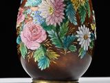 a vase with flowers painted on it sitting on a table