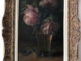 tableau représentant des fleurs roses dans un vase en verre posé sur une table