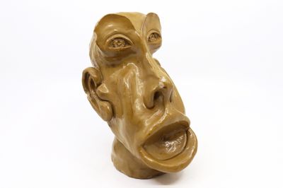 une sculpture représentant le visage d'un homme sur une surface blanche