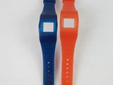 two watches sitting next to each other on a white surface