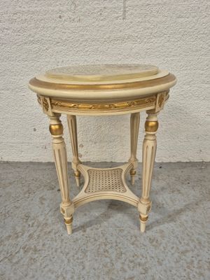 une photo d'une petite table avec un plateau en marbre posée sur un sol en béton