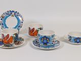 three cups and two saucers on a white table