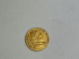 a close up of a gold coin on a white surface