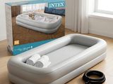 un matelas gonflable avec deux rouleaux de papier toilette à côté