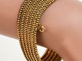 un gros plan sur la main d'une personne portant un bracelet en or