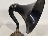 une enceinte rétro noire et argentée posée sur une surface blanche