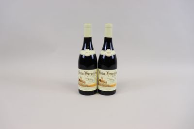 deux bouteilles de vin posées l'une à côté de l'autre sur une surface blanche