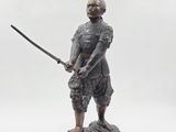 a statue of a man with a sword on a rock