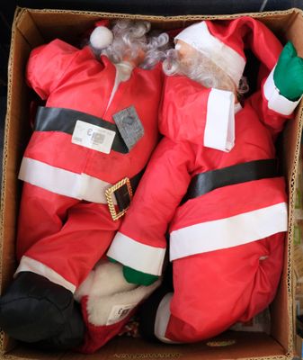 deux peluches représentant le Père Noël dans une boîte en carton