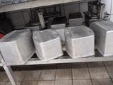 four metal containers sitting on a metal shelf in a kitchen