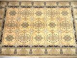 a beige rug with a blue border on a grey floor