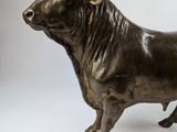 bronze statue of a bull on a white background