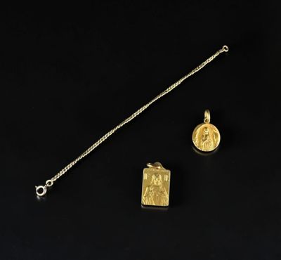 un collier en or avec un petit pendentif et un autre petit pendentif suspendu à une chaîne