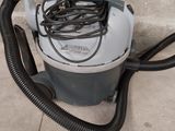 un aspirateur posé par terre près d'un mur