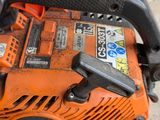 an orange and black chainsaw sitting on top of a cement floor