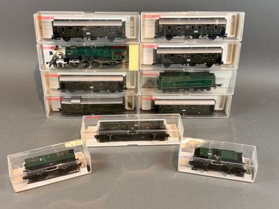 trois trains miniatures sont exposés dans une vitrine posée sur une table