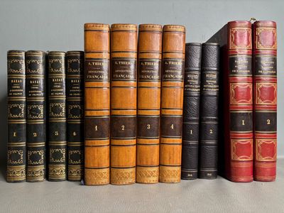 plusieurs vieux livres sont alignés sur une étagère, les uns à côté des autres