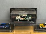 three different models of cars in plastic cases on a wooden surface