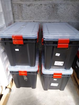 two plastic storage boxes sitting next to each other on the floor