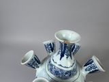 a blue and white teapot with four cups on it