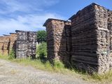 une photo montrant une rangée de vieux bâtiments en briques au bord d'un chemin de terre