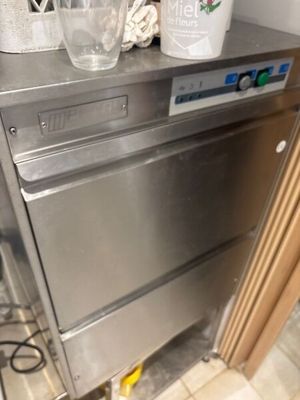 un lave-vaisselle argenté posé sur un plan de travail dans une cuisine