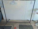 two mats on the floor next to a clothes rack