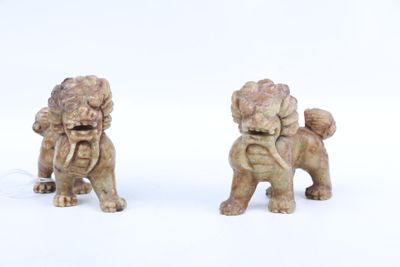 deux figurines représentant un chien et un lion sur un fond blanc