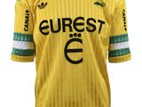 un gros plan sur un maillot de foot jaune orné d'une bande verte et blanche