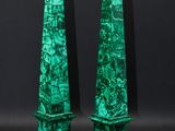 a pair of green marble obelisks with gold numbers on them