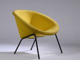 une chaise jaune posée sur un piètement en métal noir