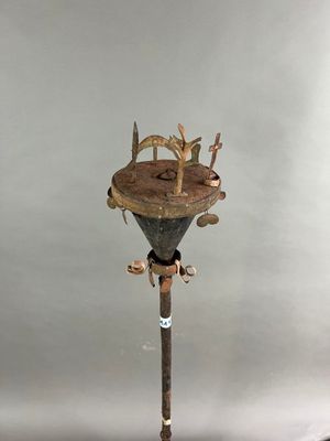 une sculpture représentant un homme sur un poteau sur lequel est perché un oiseau
