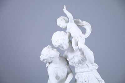 a white statue of a boy and a girl on a pedestal