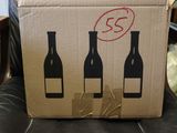 a cardboard box with three bottles of wine in it