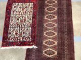 two rugs on the floor in a room next to a chair
